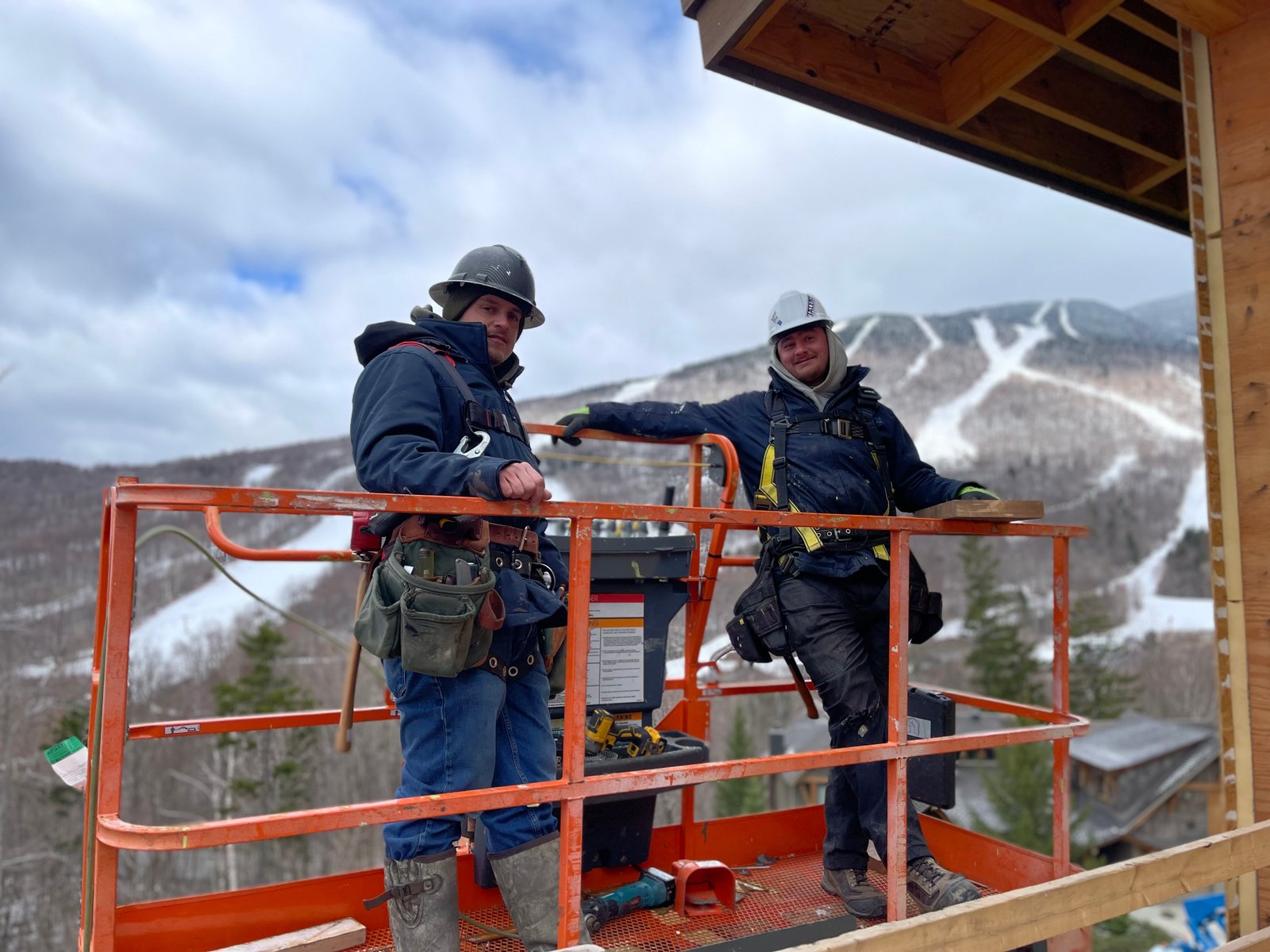 Lakeshore Construction crew on a lift with the Vermont mountains behind them