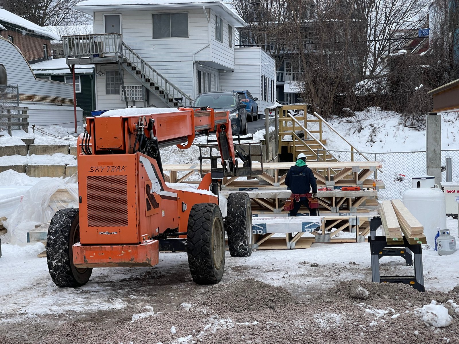 Telehandler moving framing lumber on a Vermont winter build site